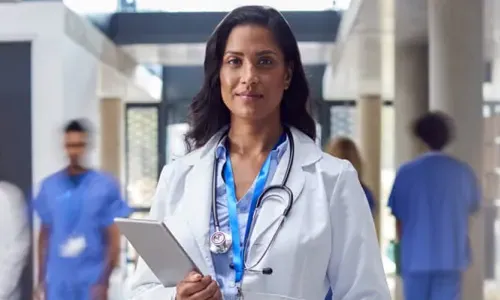 AG Acute Care Nurse Practitioner Holding Clipboard in Hospital